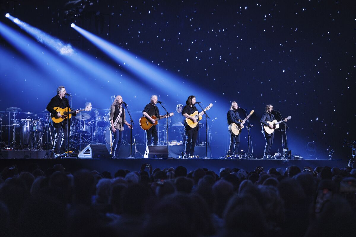 The Eagles performing on stage at Sphere under blue beams of light