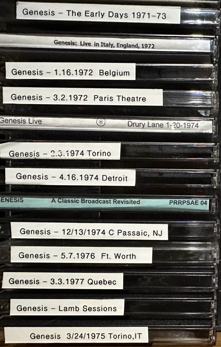 Stack of CD cases with handwritten labels for Genesis bootleg recordings from 1972 to 1977, including a Lamb Sessions disc